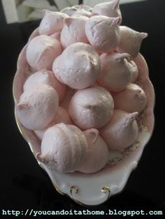 a white bowl filled with pink marshmallows on top of a black table