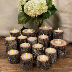 a bunch of candles sitting on top of a table next to a vase filled with flowers