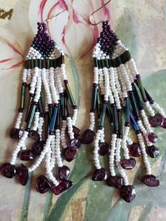 This is a pair of vintage, hand made seed bead earrings. They are made up of white pearle beads, garnet colored beads as well as green/purple iridescent beads and garnets on the bottom. They are hanging, dangling earrings. In addition to seed beads there are long narrow beads as well. They hang from sterling silver French hooks. These earrings measure 4 inches in length, including the French hooks. Don't forget to stop in at my other Etsy shop... http://www.etsy.com/shop/xtdesigns. Follow me on White Beaded Earrings With Round Beads And Bead Caps, White Beaded Earrings With Bead Caps, White Bohemian Earrings With Spacer Beads, Bohemian White Beaded Earrings With Spacer Beads, Beach Boho, Dangling Earrings, Seed Bead Earrings, Bead Earrings, Earrings Sterling Silver