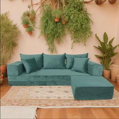 a living room filled with lots of green furniture and potted plants on the wall