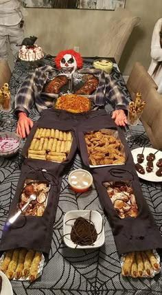 a table filled with lots of food on top of a dining room table covered in black cloths