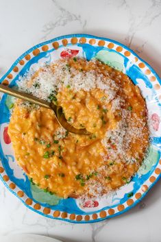 a bowl of macaroni and cheese on a plate with a spoon in it