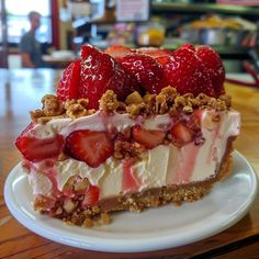 a piece of cheesecake with strawberries and nuts on top sits on a plate