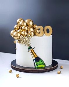 a birthday cake decorated with gold balloons and a champagne bottle