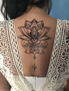 the back of a woman's neck with a lotus tattoo on it