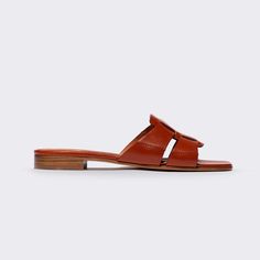 A modern fisherman slide with a directional square toe and interlocking front strap, the small stacked heel, and calfskin finish of the Leo lends a sophisticated finish to contemporary tailoring, whether styled with skirts, pants, or shorts. Please note that these shoes are made from vachetta, a vegetable-tanned calfskin leather and they will need to be broken in on most feet. Over time this high-quality leather will change its shape and mold to your foot for optimal comfort. DETAILS Materials: