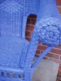 a blue chair sitting next to a brick wall