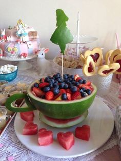 a watermelon bowl filled with blueberries and strawberries in the shape of trees