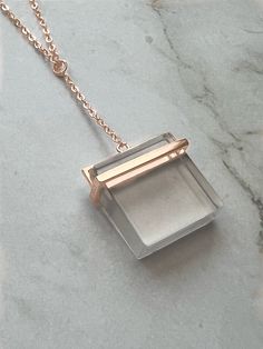 This stunning necklace features a square clear quartz crystal pendant that dangles gracefully from a sterling silver chain with a 14K rose gold plating. The combination of the clear crystal and the warm rose gold create a beautiful contrast that adds elegance and sophistication to any outfit. The quartz crystal is known for its healing properties, making this necklace not only a stylish accessory, but also a meaningful piece of jewelry that can be worn for any occasion. 925 Sterling Silver Rose Elegant Rose Gold Crystal Necklaces With Adjustable Chain, Elegant Rose Gold Crystal Necklace With Adjustable Chain, Elegant Rose Gold Crystal Necklace With Delicate Chain, Rose Gold Square Pendant Jewelry In Sterling Silver, Rose Gold Sterling Silver Square Pendant Jewelry, Rectangular Rose Gold Sterling Silver Jewelry, Minimalist Rose Gold Crystal Pendant Necklace, Rose Gold Sterling Silver Rectangular Pendant Jewelry, Rose Gold Sterling Silver Jewelry With Rectangular Pendant