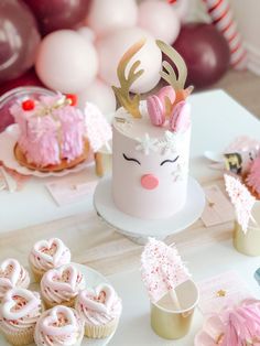 a table topped with cupcakes and cakes covered in frosting