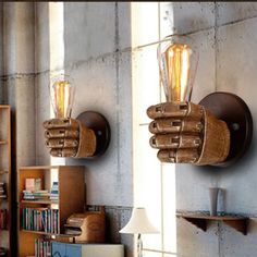 two light fixtures mounted to the side of a wall next to a book shelf and bookshelf