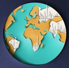 a paper cut world map on a blue background with white and yellow buildings in the distance