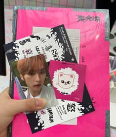 a person holding up some stickers on a pink bag