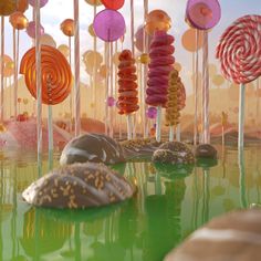 there are many candy lollipops on the table and in the background is water