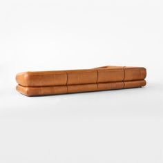 a brown leather couch sitting on top of a white floor