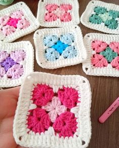 crocheted squares with hearts on them sitting on a table