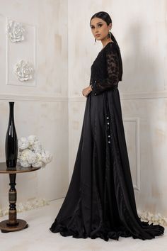 Black beauty gown bodice is made on machine floral embroidery net, which is followed by handwork of black sitara, crystals, beads work with an enchanting full length silk gown paired with khadi net dupatta with beads on border to give a royal look. Color: Black Shirt: khadi net and silk Dupatta Khadi Net Shirt length: 64” All outfits are fully lined Lining in sleeves is complimentary just mention in custom text box if needed Please refer size guide before selecting size For customized measuremen Semi-stitched Evening Dress With Sheer Dupatta, Black Gown With Resham Embroidery And Traditional Drape, Black Gown With Intricate Embroidery, Traditional Drape, Black Resham Embroidered Evening Gown, Black Gown With Traditional Drape For Eid, Black Resham Embroidery Evening Gown, Floor-length Pearl Embroidered Gown For Eid, Floor-length Gown With Pearl Embroidery For Eid, Black Embellished Organza Sets