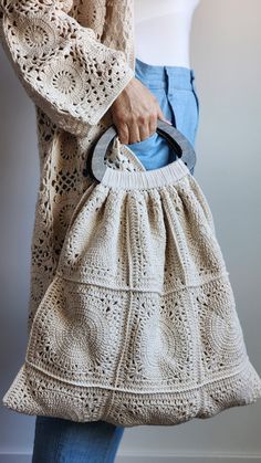 a woman is holding a crocheted bag