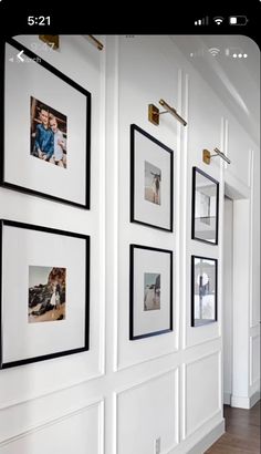 a white wall with black and white pictures hanging on it's sides, along with wooden flooring