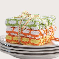 stack of crocheted dishcloths on plates with ribbon tied around the edges