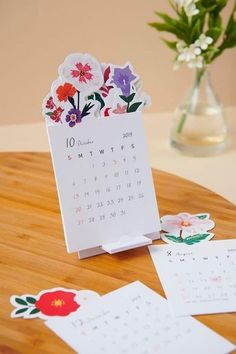 a wooden table topped with cards and flowers