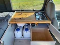 the inside of a camper with an oven, sink and storage drawers in it