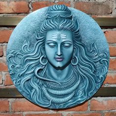 a statue of a woman with long hair and eyes closed, on a brick wall