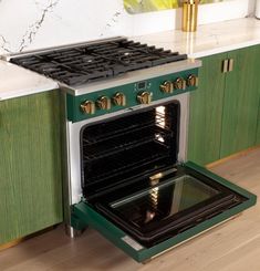 a green and white stove top oven in a kitchen next to cabinets with marble counter tops