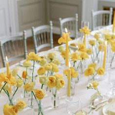 a long table is set with yellow flowers and candles for a formal dinner or reception