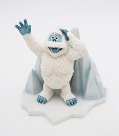 a white and blue monster figurine standing in front of an iceberg