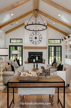 a living room filled with furniture and a large clock mounted to the wall above it