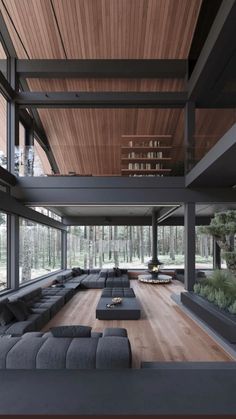 a large living room with black couches and wooden ceilinging in front of windows