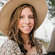 a woman wearing a hat and smiling for the camera