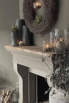 a mantle with candles and wreaths on it