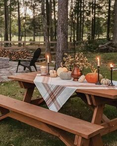 a picnic table with candles and pumpkins on it