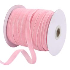 a roll of pink velvet cord with a white ribbon on the top and one end