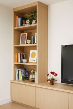 a television sitting on top of a wooden shelf