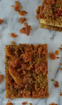 three pieces of cake sitting on top of a marble counter next to another piece of food