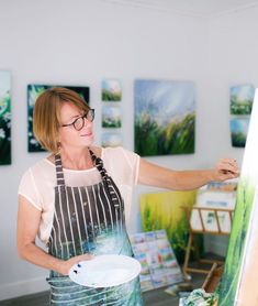 a woman in an apron painting on canvass