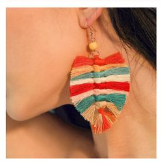 a woman wearing colorful earrings with tassels