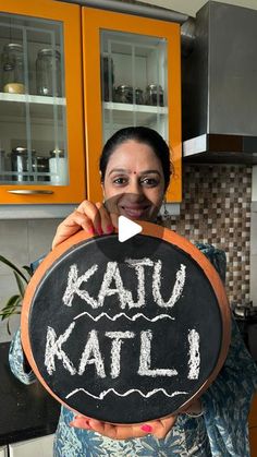 a woman holding up a chalk board with the words kalu kalti written on it