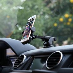 a car dashboard with a cell phone in the air on it's holder and windshield