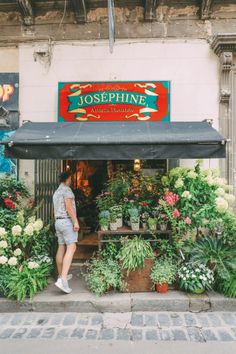 a man standing in front of a flower shop