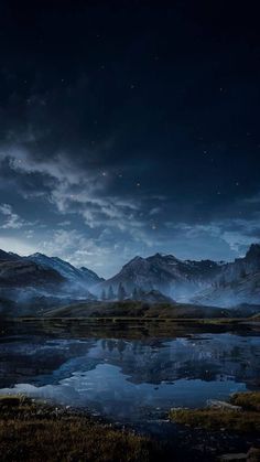 the mountains are reflected in the still water at night with stars and clouds above them