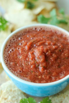 a bowl of salsa with tortilla chips on the side