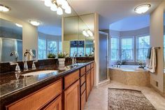 a large bathroom with two sinks and a bathtub next to a walk in shower