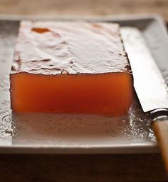 a piece of cake on a plate with a knife next to it and some water