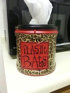 a microwave oven with a plastic bag in the front and a leopard print canister on top