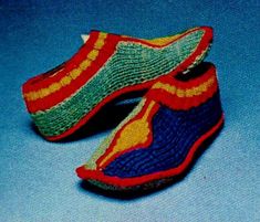 two pairs of slippers made out of knitted material on a blue tablecloth