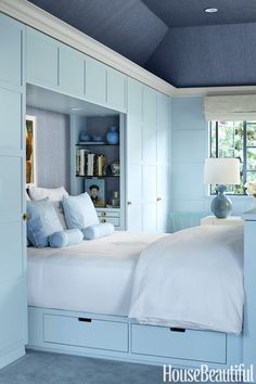 a bedroom with blue walls and white furniture